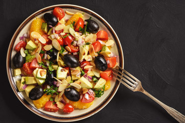 Salad with oranges, olives, tomatoes, avocado and almond.