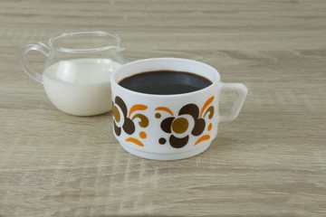 RETRO FLOWER COFFEE CUP
Small retro flower coffee cup with black coffee and milk jar on a wood table.