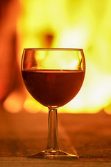 Glass of red wine; and wool; things near cozy fireplace.