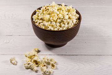 Bowl with popcorn on wooden table