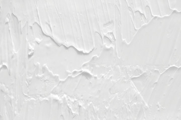 Texture of white cream. Background with a smooth and shiny surface with waves.