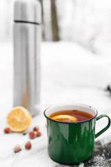 tea with lemon and cardamom on the background of a snow-covered table