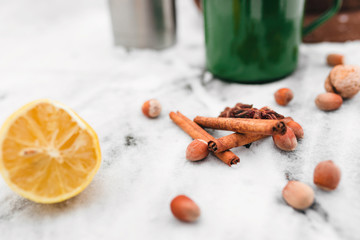 cinnamon, hazelnuts, cardamom on snow-covered glass in the forest
