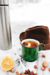 tea with lemon and cardamom on the background of a snow-covered table