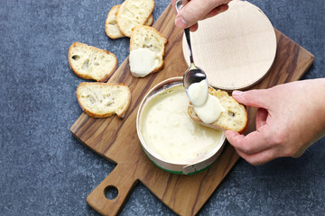 french vacherin mont d'or, soft cheese with washed rind, scooping with a spoon