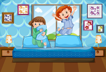 Two girls in pajamas jumping on bed