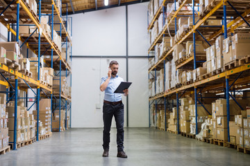 Warehouse worker or supervisor with a smartphone.