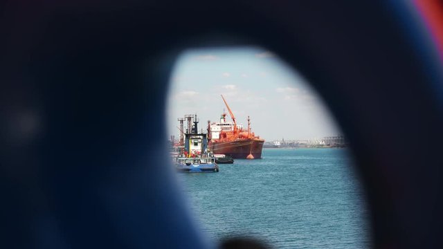 Ukraine - May 2016: Overview of sea port with big orange gas carrier and tow near pier