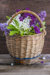 Fototapeta na wymiar bouquet of purple and white lilac flowers in old wicker basket