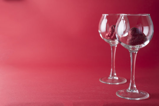 Red hearts in a glasses isolated on red background