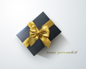 Black gift box with glittering golden bow and ribbons.
