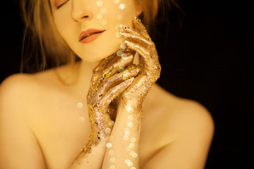 Beautiful woman in gold, golden hands, glitter sensual glamour studio shoot