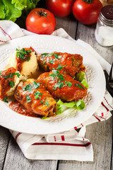 Stuffed cabbage with meat and rice served with boiled potatoes and tomato sauce