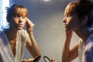 Mujer joven maquillandose en el baño