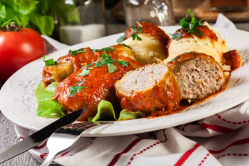 Stuffed cabbage with meat and rice served with boiled potatoes and tomato sauce