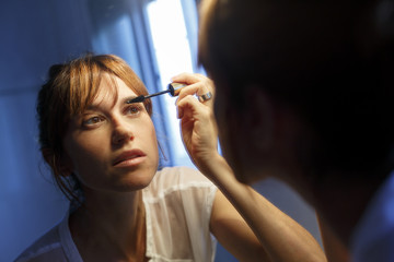 mujer joven maquillandose en el baño