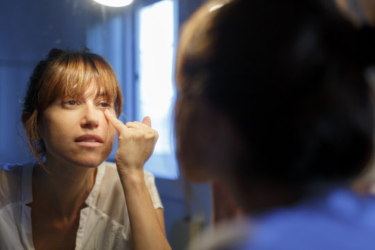 mujer joven maquillandose en el ba&ntilde;o