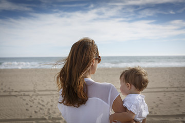 Madre joven en la playa con su hija