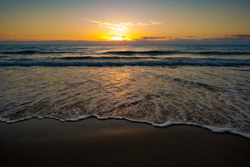 Fototapeta na wymiar sunset or sunrise on the sea with a sandy beach. Calm sea at dusk