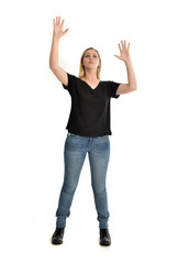 full length portrait of blonde girl wearing black shirt and jeans, standing pose isolated on a...