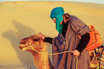 Woman with a camel in the Sahara desert.