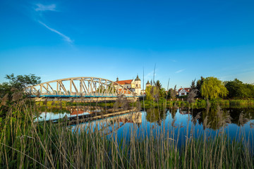 View at bridge over the Narew river and baroque Church of the Holy Trinity in Tykocin town, Podlasie, Poland