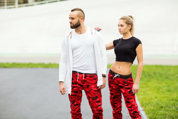 fashion guy with a girl posing in the same sportswear