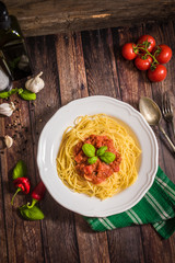 Spaghetti pasta with tomato sauce  and fresh basil - homemade healthy italian pasta on rustic wooden background