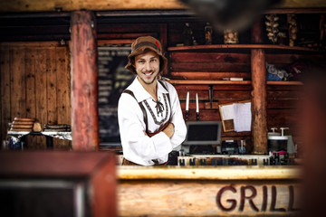 Obraz premium Bavarian man and his own small business. Grill bar interior. 