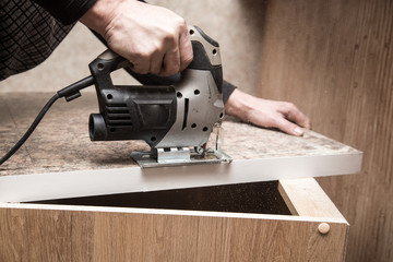 Master cuts wood with a jig saw