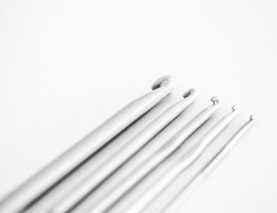 various sizes of aluminum crochet knitting needles. black and white photo