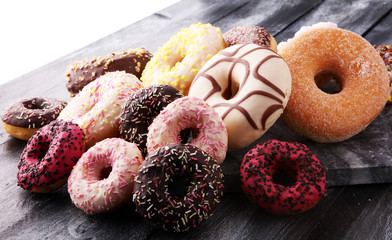 assorted donuts with chocolate frosted, pink glazed and sprinkles donuts.