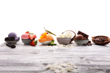 Set of ice cream scoops of different colors and flavours with berries, nuts and fruits