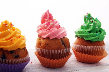 Tasty cupcakes on wooden background. Birthday cupcake in rainbow colors