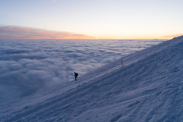 Skiing on snow in Slovak mountains above clouds during sunset in winter
