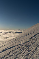 Beautiful sunset above clouds in snow covered Low Tatras mountains during susnet in winter