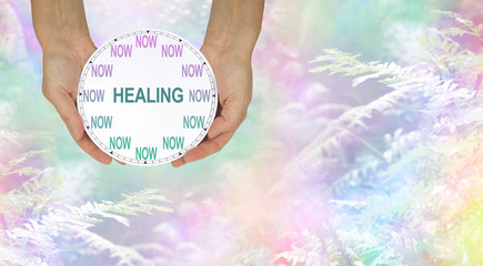 The time for healing is NOW - female hands holding a clock with no hands that has NOW in place of...