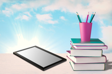 Tablet and pile of books