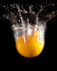 Orange under water on a black background