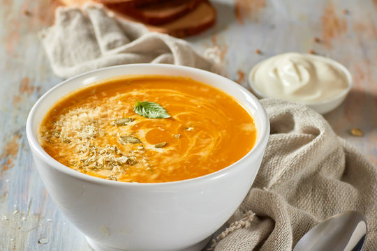 Bowl of pumpkin soup with cheese and cream