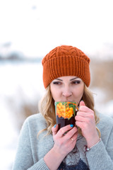 beautiful girl in a fur vest walks in a field in the snow