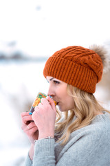 beautiful girl in a fur vest walks in a field in the snow