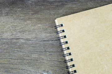 Brown notebook placed on old wooden floor.