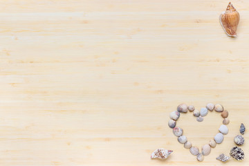 Drewniane tło z sercem ułożonym z muszli. Tło z wolną przestrzenią i motywem walentynkowym. © art08