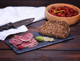 sliced smoked salami sausages and pieces of rye bread