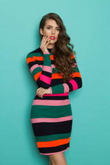 Beautiful Woman In Vibrant Striped Dress Is Holding Hand On Chin