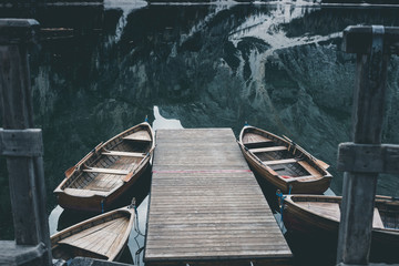 Wooden boats at the Alpine mountain lake. Braies lake, Dolomites, Italy.