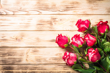 Naklejka na ściany i meble Red rose flower on wooden table. 