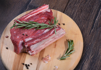 Raw beef ribs on a round cutting board