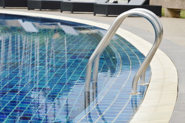 iron stair on blue tile swimming pool